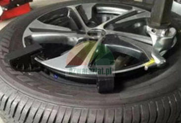 Kolo automobilu na zouvačce pneumatik v profesionálním servisu.