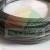 Detailní záběr na smotané ocelové lano se splétanou strukturou na bílém pozadí.