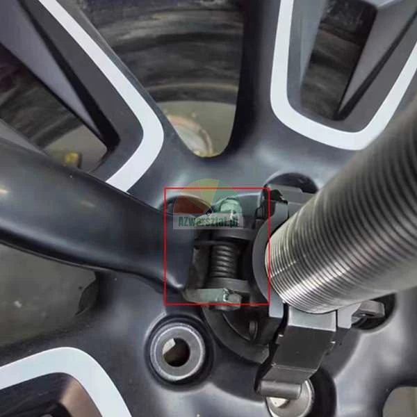 Detailní záběr na upínací mechanismus vyvažovačky kol na paprsku černého disku, označený červeným čtvercem.