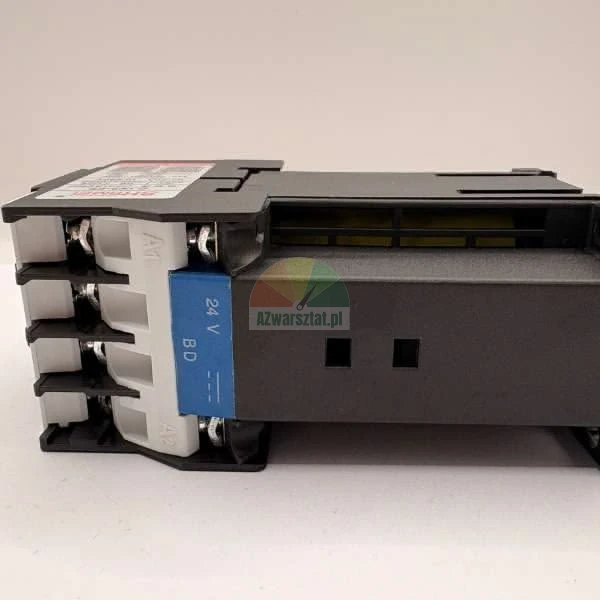 Černý průmyslový stykač nebo elektrické relé s viditelnými šroubovými svorkami, bílou částí krytu s označením A1 a A2 a modrým štítkem s nápisem 24 V BD.